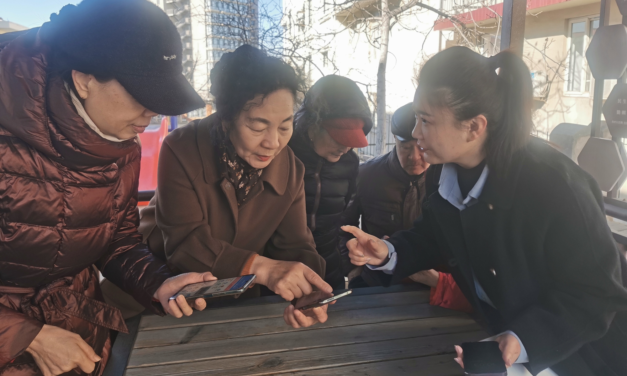 Li Dandan (right) introduces various elderly care services provided by the community that can be accessed on the phone to the elderly in the Dongjing Road Community, Qinhuangdao, on February 15, 2024. Photo: Courtesy of Li