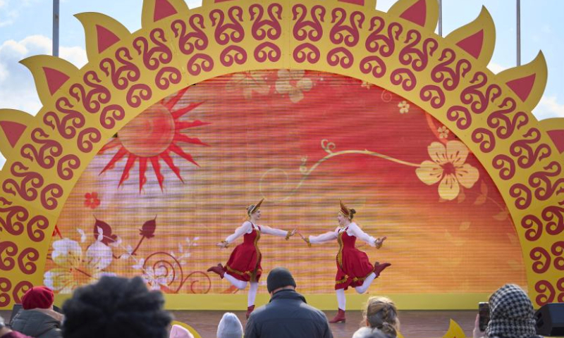 People watch a performance in the central square in Vladivostok, Russia, March 17, 2024. On Sunday, the Russian Far East city of Vladivostok celebrates Maslenitsa, bidding winter farewell and welcoming spring. Locals engage in traditional games and enjoy blini in the central square. (Photo by Guo Feizhou/Xinhua)