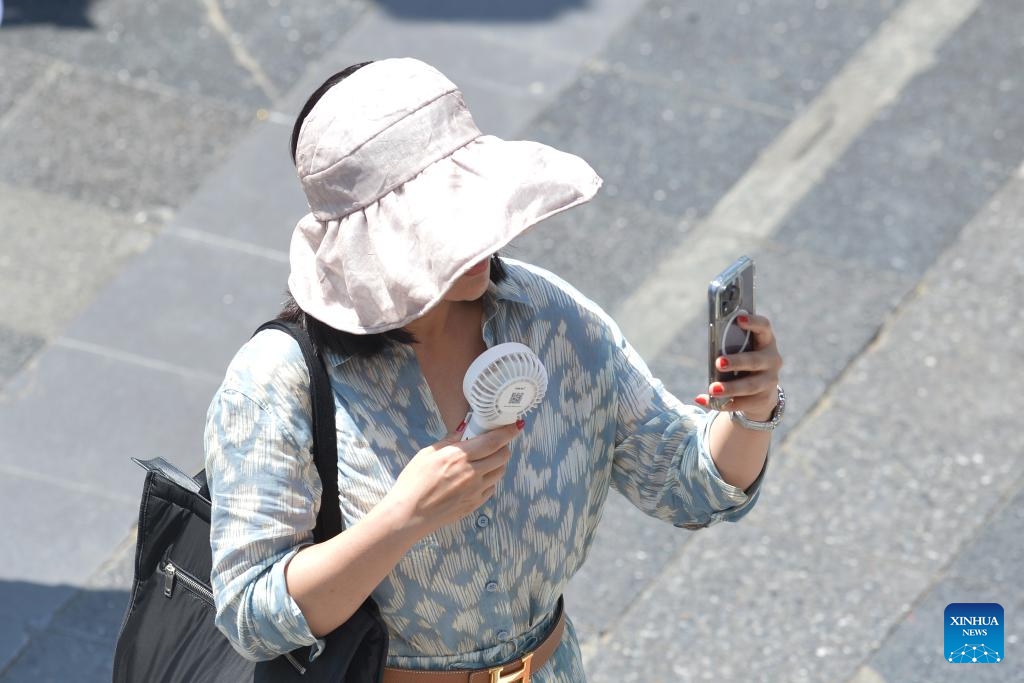 A pedestrian cools herself with a mini electric fan in Bangkok, Thailand, March 5, 2024.((Photo: Xinhua)