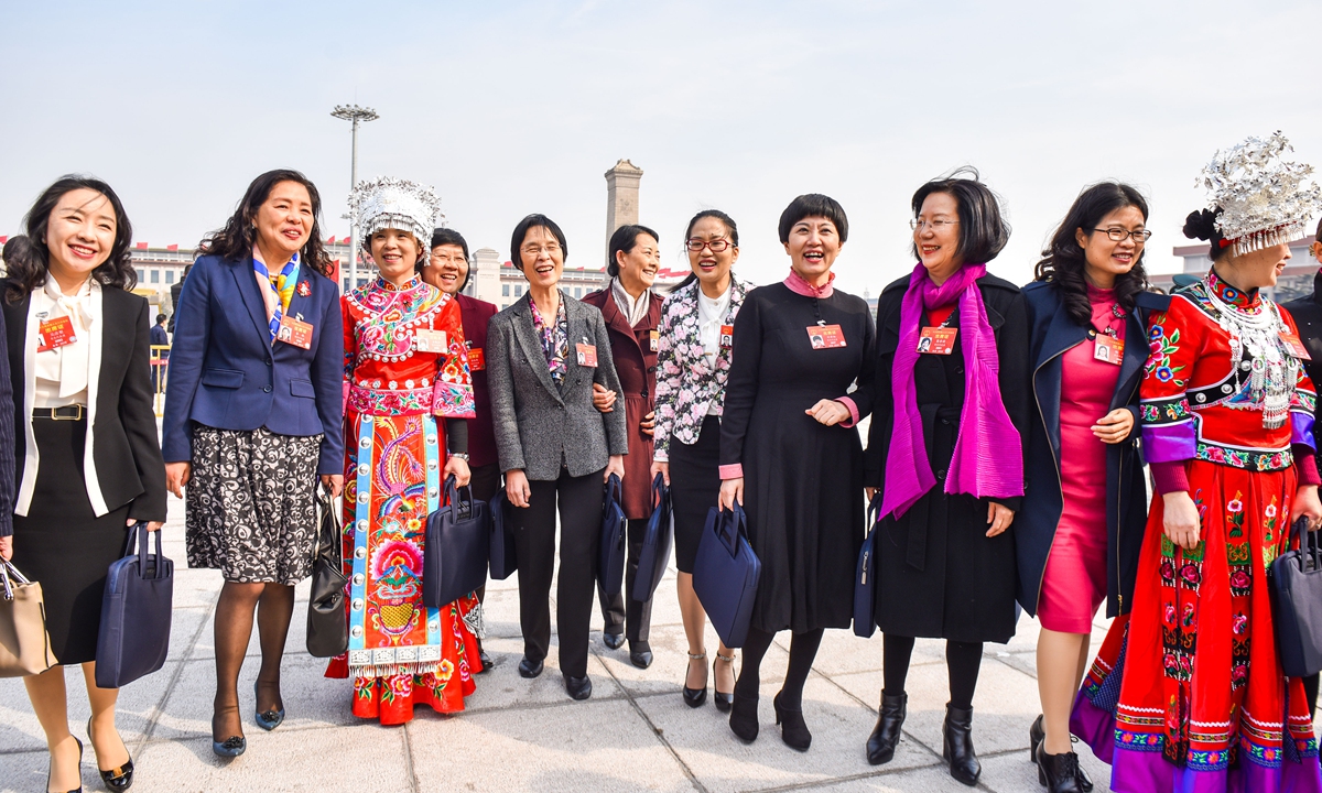 Female deputies to the National People's Congress from the Chongqing delegation approach the meeting venue during the two sessions in Beijing. Photo: VCG  