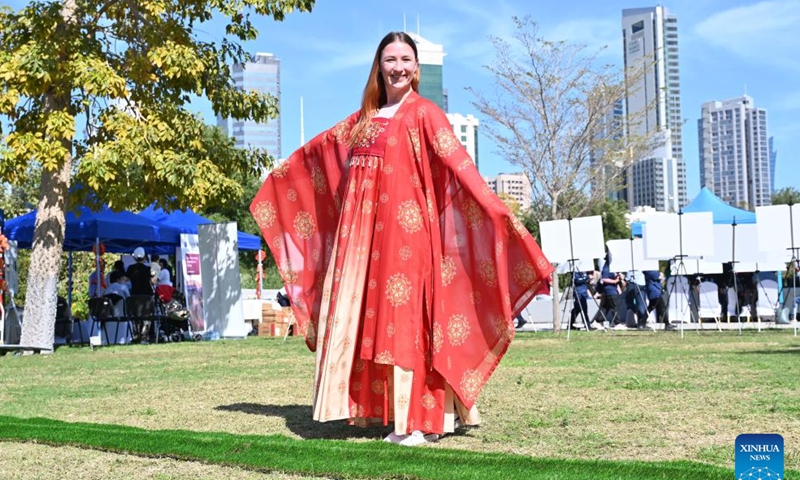 A woman wearing traditional Chinese attire poses for photos during the Chinese Culture and Food Festival at the Sheikh Jaber Al-Ahmad Cultural Centre in the Capital Governorate, Kuwait, on March 9, 2024. The Chinese Culture and Food Festival was held here on Saturday. (Photo by Asad/Xinhua)