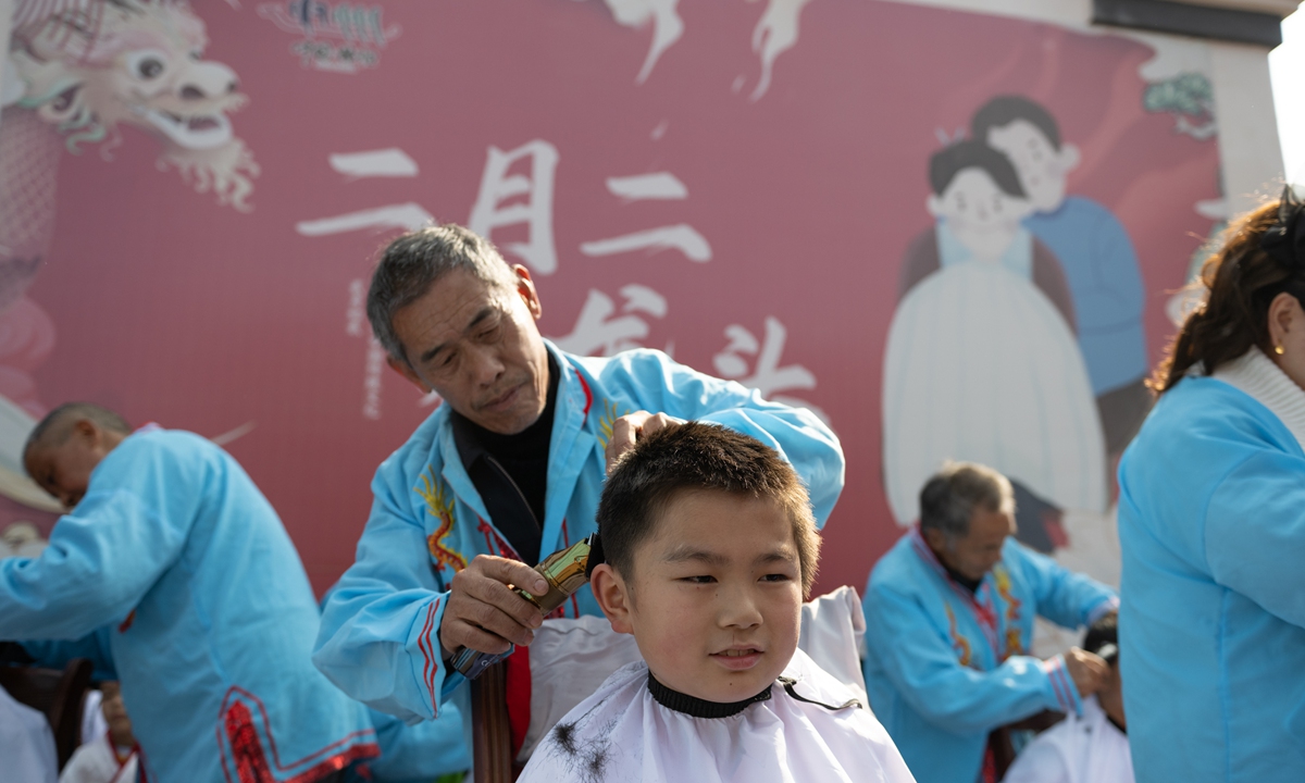 A barber shaves the head of a child in Yichang, Central China's Hubei Province, on March 11, 2024. This day marks the second day of the second month of the traditional Chinese calendar. On this day, people would cut their hair and wish for good luck for the whole year. Photo: VCG