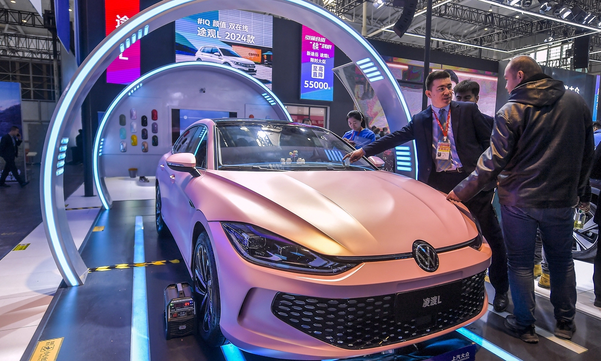 A visitor examines and asks about a Volkswagen car at an international auto show in Urumqi, capital of Northwest China's Xinjiang Uygur Autonomous Region, on March 13, 2024. The show attracted more than 100 auto brands, local media reported. Xinjiang's regional GDP grew by 6.8 percent year-on-year, compared with the national growth rate of 5.2 percent in 2023.Photo: VCG