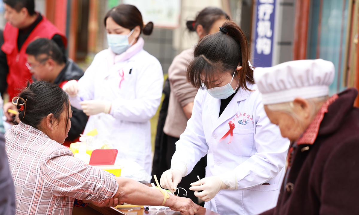 Staff members of local center for disease control and prevention conduct free HIV/AIDS screening for residents in a community in Tongren, Southwest China's Guizhou Province, on December 1, 2023.
