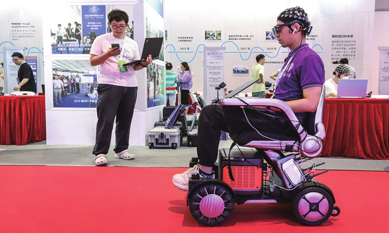 A staff member demonstrates a brain-controlled smart wheelchair at the World Robot Expo in Beijing on August 16, 2023. Photo: VCG