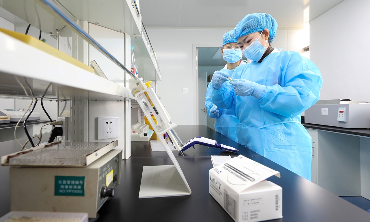 A doctor tests the blood sample of an AIDS patient at a county-level disease control center in Tongren, on December 1, 2021. Photo: VCG

