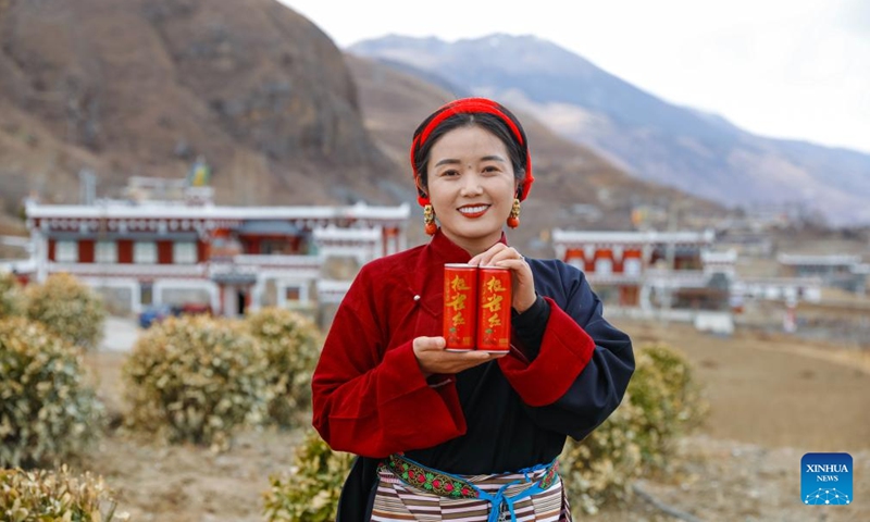 A woman shows beverage products made from Cut-leaf Crabapple in Daofu County, southwest China's Sichuan Province, March 10, 2024. Growing in China's western Sichuan, southeastern Gansu and southeastern Xizang and other plateau areas, the Cut-leaf Crabapple is a cash crop whose leaves and fruits can be respectively made into herbal tea and beverage.(Photo: Xinhua)