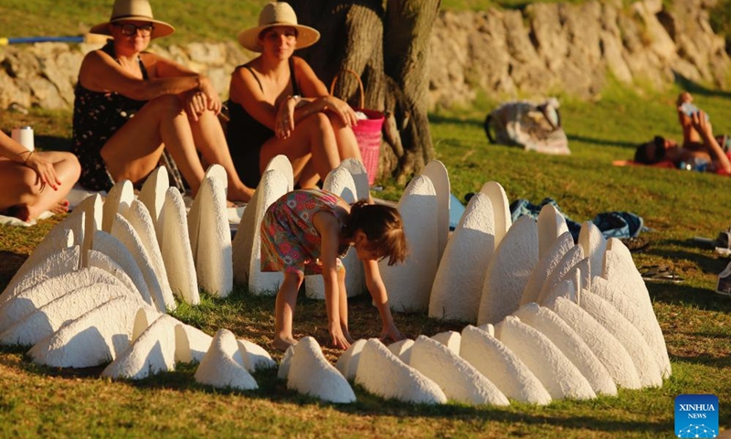 A girl plays near an artwork on Cottesloe Beach in Perth, Australia, March 13, 2024. The 20th Sculpture by the Sea, Cottesloe is held here from March 1 to March 18 this year.(Photo: Xinhua)