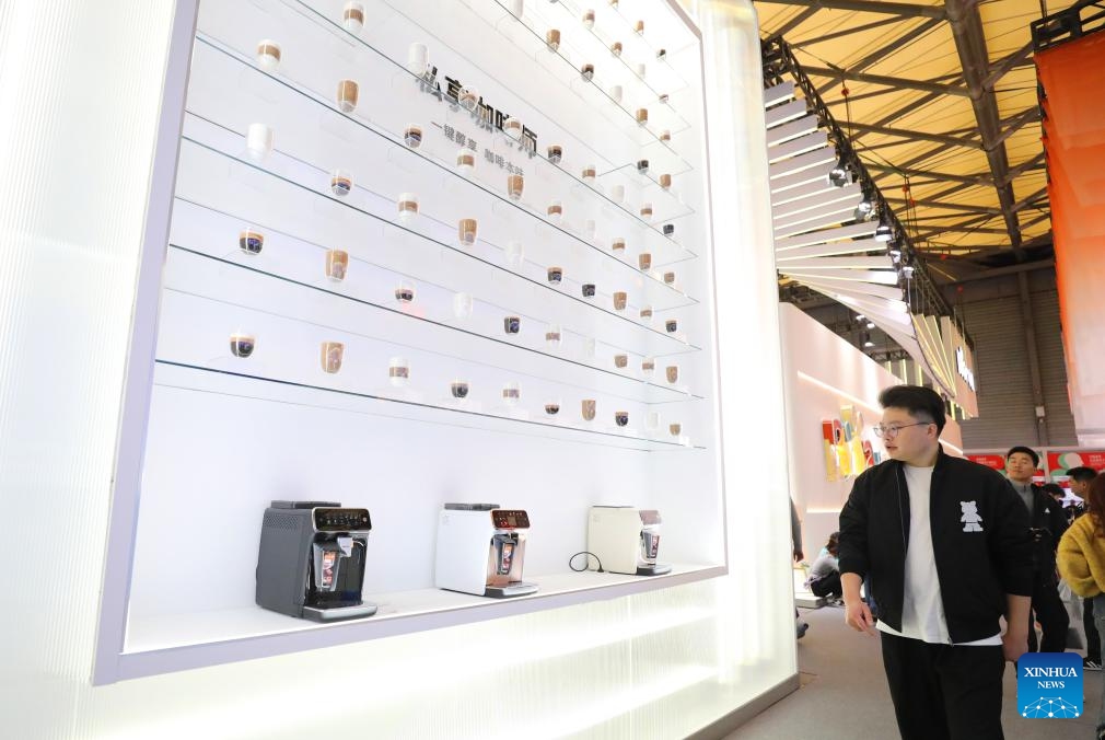 A visitor walks past the display wall of Philips's coffee machine products during the 2024 Appliance & Electronics World Expo (AWE2024) in east China's Shanghai, March 14, 2024. With the theme of Smartize the Future, the AWE2024 kicked off here on Thursday. The world's leading brands in the field of home appliances and consumer electronics gathered at the expo to showcase their latest innovations.(Photo: Xinhua)