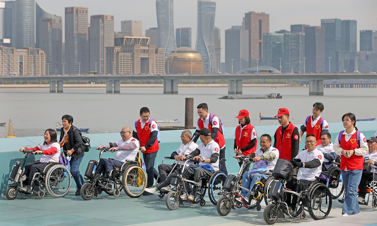 People with disabilities and volunteers roam together in Hangzhou, East China's Zhejiang, on April 3, 2023. Photos: VCG