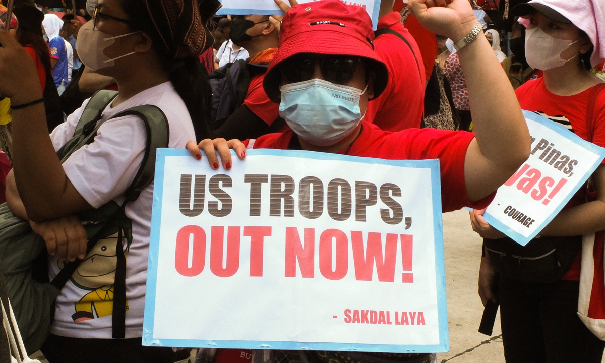 A protester holds a placard with the slogan calling the US troops to leave the Philippines during a demonstration in front of the US Embassy in Manila on May 1, 2023. Photo: VCG