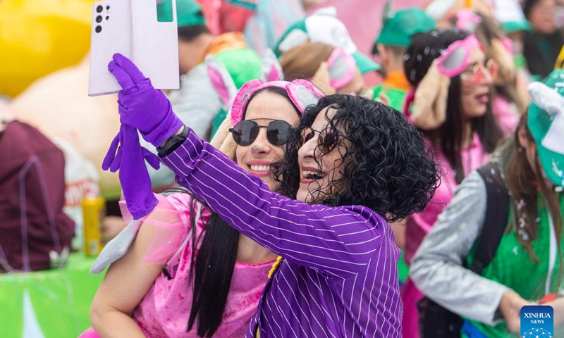 Two women take selfies during the traditional Limassol Carnival parade in Limassol, Cyprus, March 17, 2024(Photo: Xinhua)