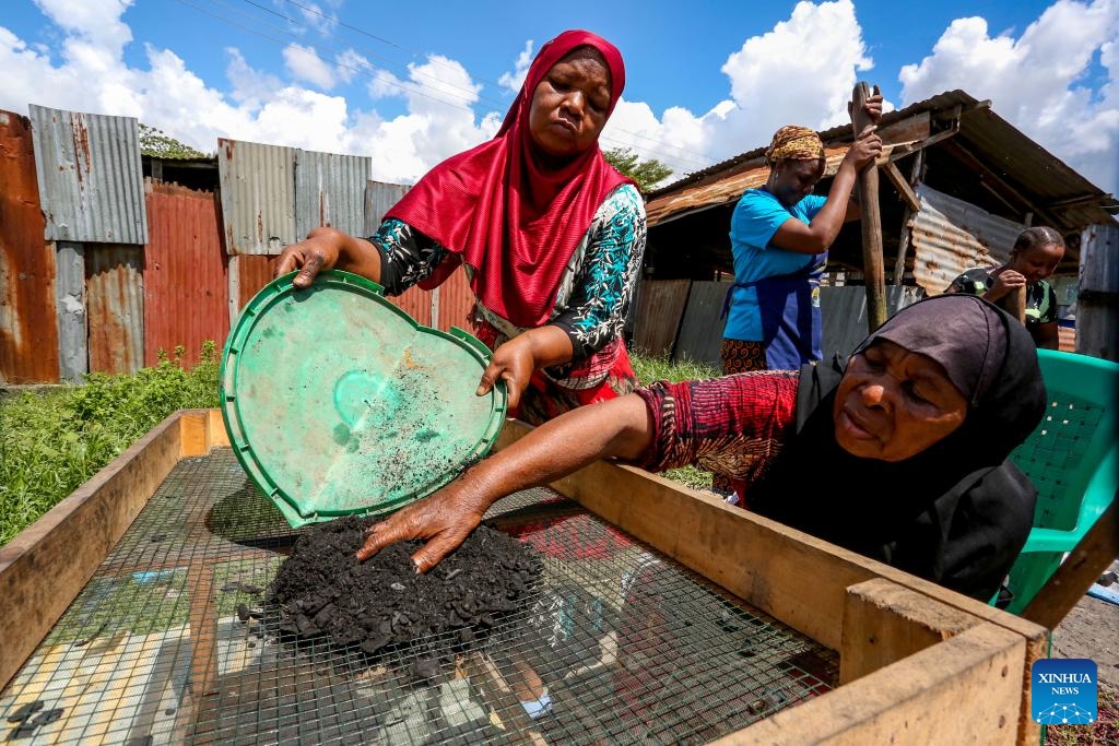 Members of a women's group use coconut shells, dried banana peels and dried cassava stalks to make charcoal at a street workshop in Dar es Salaam, Tanzania, on March 16, 2024.(Photo: Xinhua)