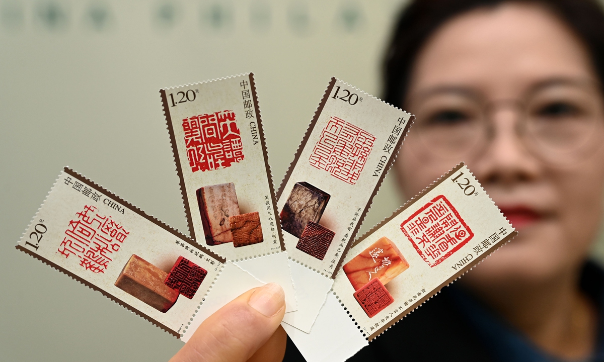 A China Post representative displays a set of four special stamps on the theme of Chinese seal cutting on March 20, 2024. The planned circulation of this stamp set is 6.98 million sets. As an art form born out of the combination of calligraphy and carving, Chinese seal cutting was once considered, along with calligraphy, painting and poetry, as one of the four essential skills required of an ancient scholar. Photo: VCG