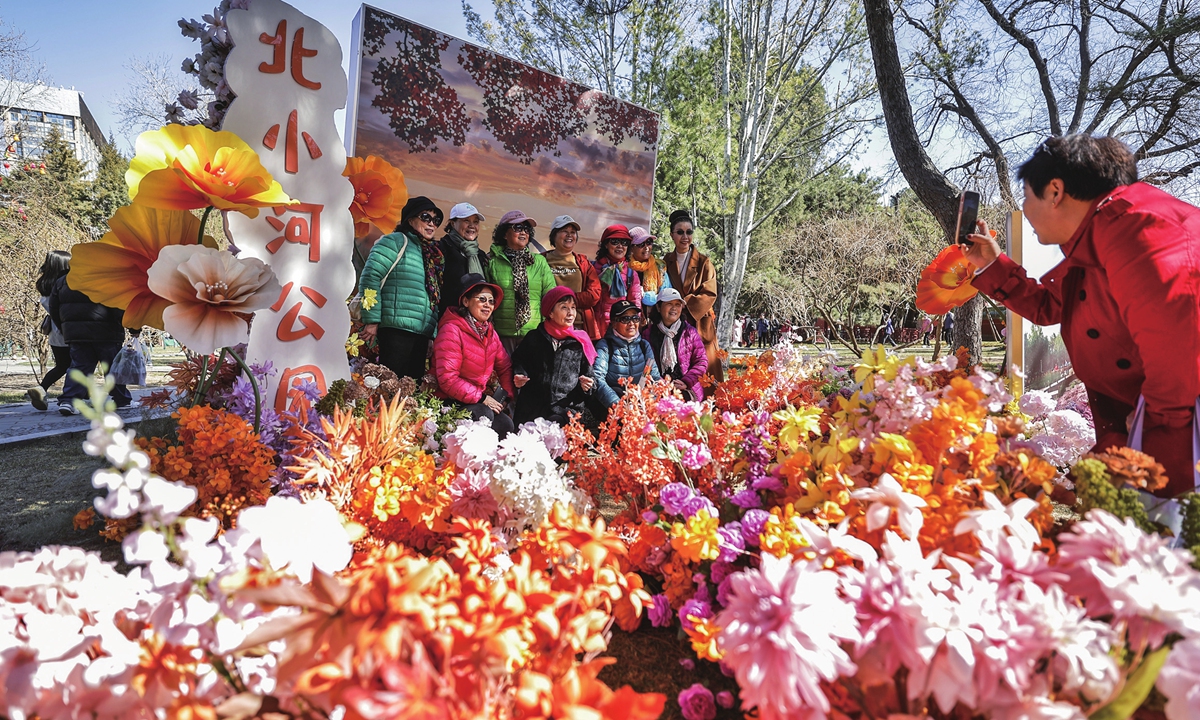 Residents take a group photo at the Chaoyang Garden Festival in Beijing on March 20, 2024. Photo: VCG