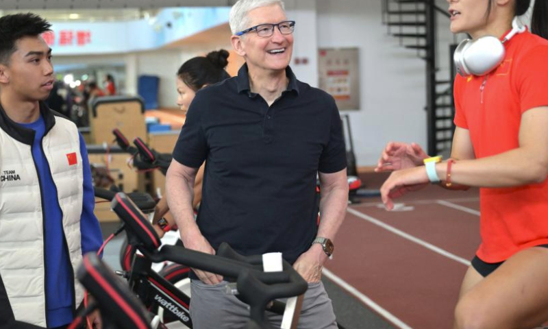 Apple CEO Tim Cook (C) chats with Chinese women's rugby player Wang Wanyu (R) in Beijing, China, March 23, 2024. Apple CEO Tim Cook visited Chinese women's rugby team on Saturday. (Xinhua/Cai Yang)