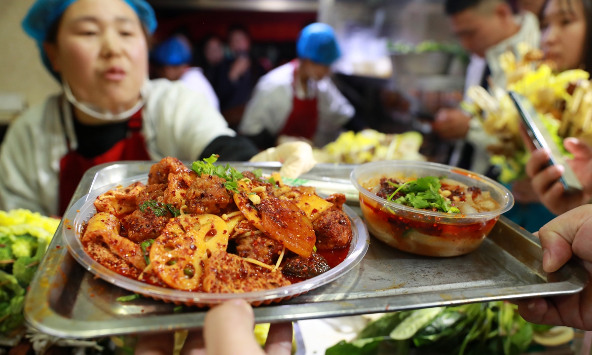 A vendor serve <em>malatang</em> to a guest in a local store in Tianshui, Gansu, on March 15, 2024. Photo: VCG