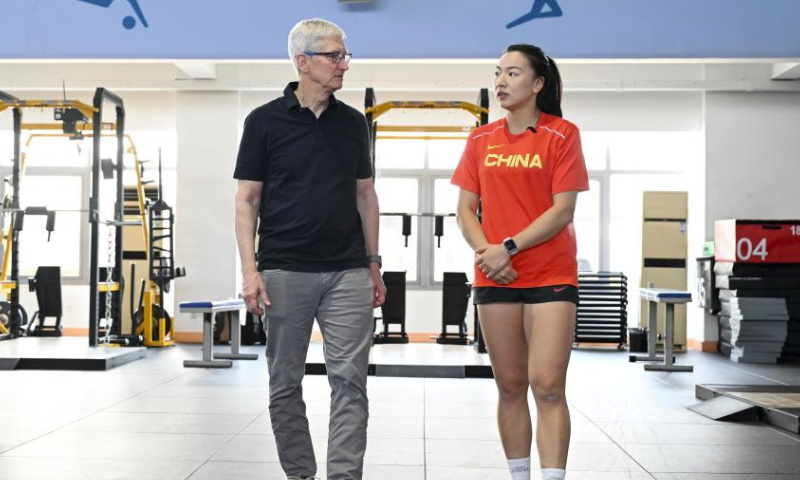 Apple CEO Tim Cook (L) chats with Chinese women's rugby player Chen Keyi in Beijing, China, March 23, 2024. Apple CEO Tim Cook visited Chinese women's rugby team on Saturday. (Xinhua/Chen Yehua)