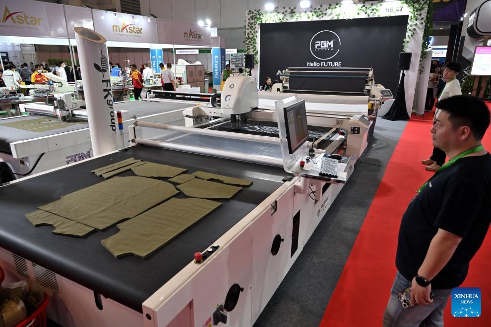 A visitor watches the operation of a fabric cutting machine during INDO INTERTEX, a major textile and garment exhibition, at Jakarta International Expo, Jakarta, Indonesia, on March 21, 2024. From March 20 to 23, more than 600 companies attend INDO INTERTEX, showcasing their newest advancements in digital printing, textile chemistry, raw materials, digital technology, apparel, accessories, and other textile products.(Photo: Xinhua)