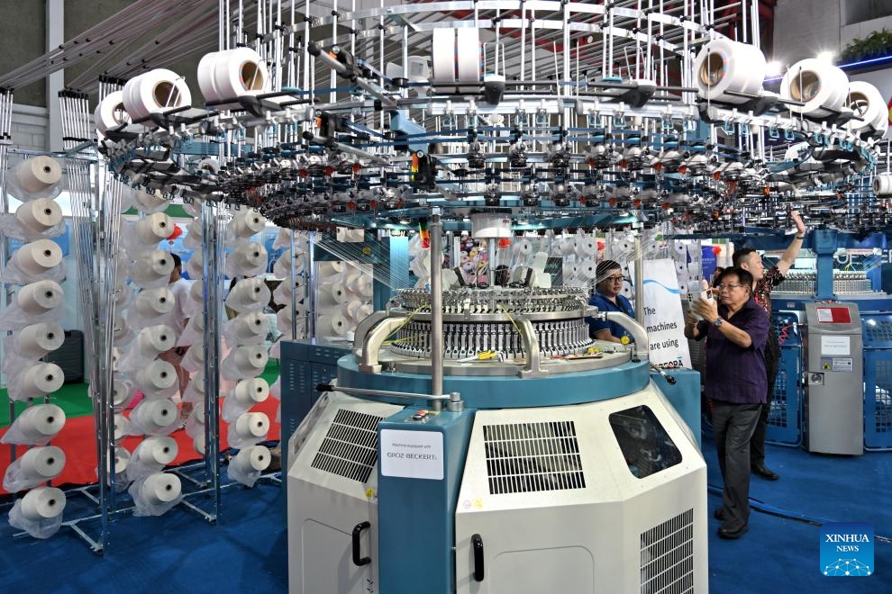 Visitors take photos of a knitting machine during INDO INTERTEX, a major textile and garment exhibition, at Jakarta International Expo, Jakarta, Indonesia, on March 21, 2024. From March 20 to 23, more than 600 companies attend INDO INTERTEX, showcasing their newest advancements in digital printing, textile chemistry, raw materials, digital technology, apparel, accessories, and other textile products.(Photo: Xinhua)