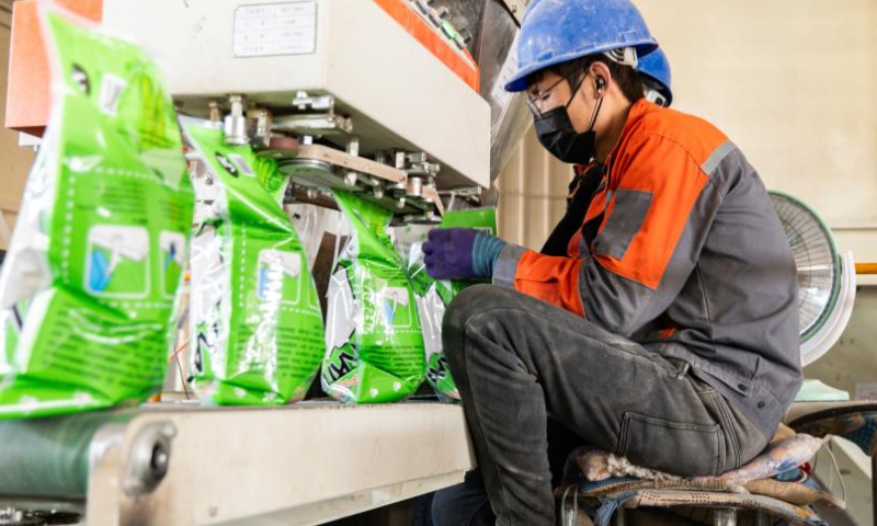 A worker operates at a production line of a cat litter manufacturer in Ningcheng County, Chifeng City, north China's Inner Mongolia Autonomous Region, March 14, 2024. (Photo by Qi Xuetao/Xinhua)