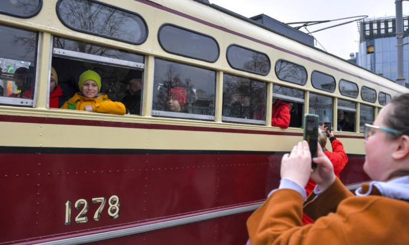 A child poses for photos inside a tram after a parade of retro tramways in Moscow, Russia, on April 6, 2024. The parade of retro tramways was held on Saturday to mark the 125th anniversary of the opening of the first tram line in Moscow. (Photo by Alexander Zemlianichenko Jr/Xinhua)