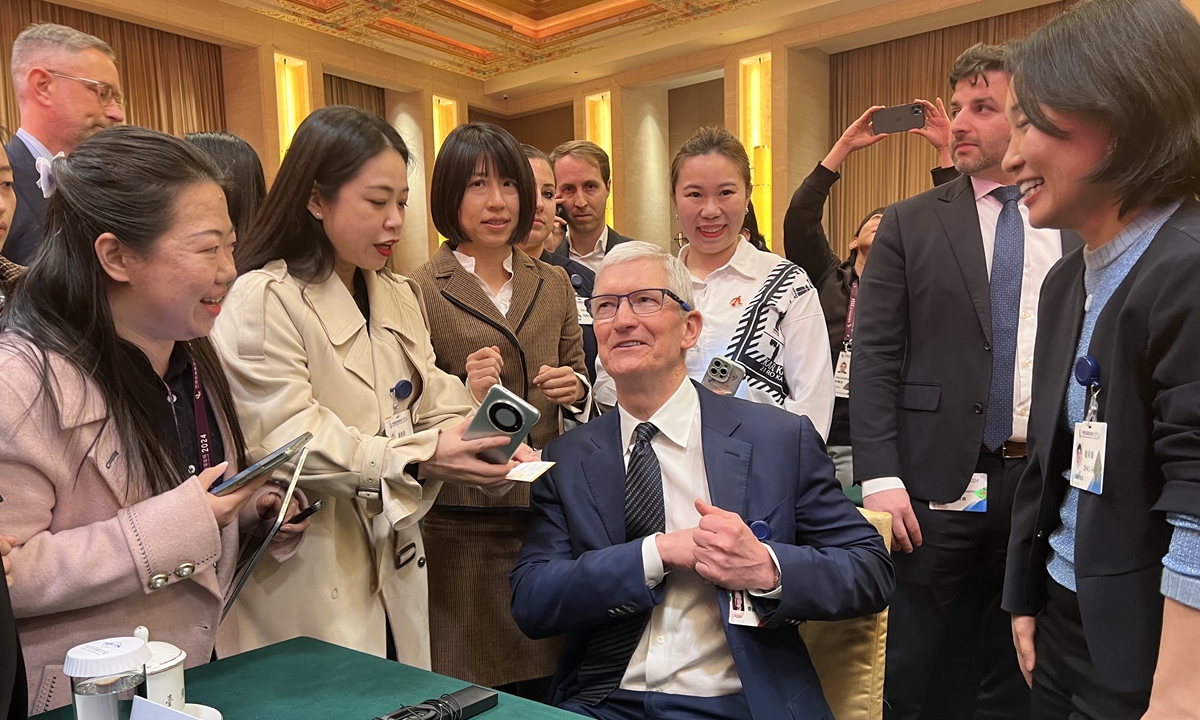 Tim Cook, chief executive officer of Apple Inc, exchanges business cards with participants at the China Development Forum 2024 in Beijing, on March 24, 2024. About 400 people, including experts, entrepreneurs, government officials and representatives of international organizations, attended the opening ceremony of the forum. Photo: VCG