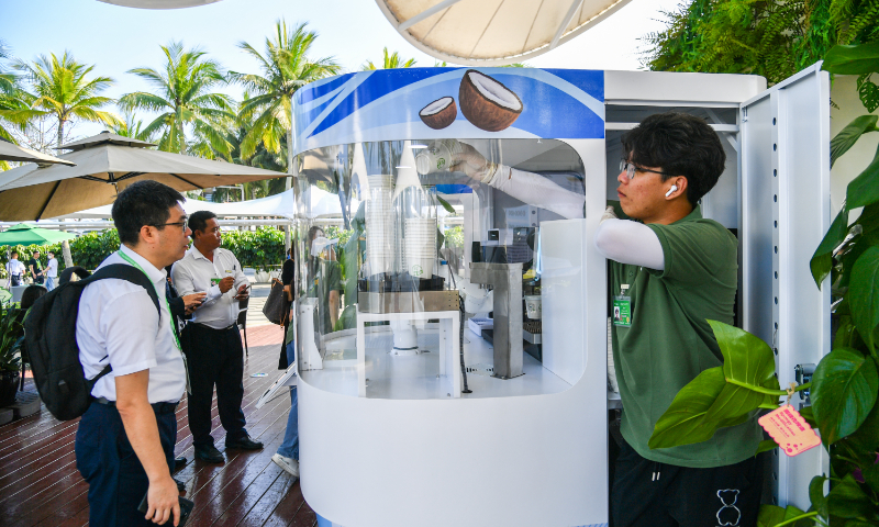 A customer waits for a cup of coffee at a zero-carbon coffee kiosk at the permanent site of the Boao Forum for Asia in Boao, South China's Hainan Province, on March 27, 2024. As one of the earliest areas to grow and process coffee in China, Hainan has a history of coffee planting for more than 100 years