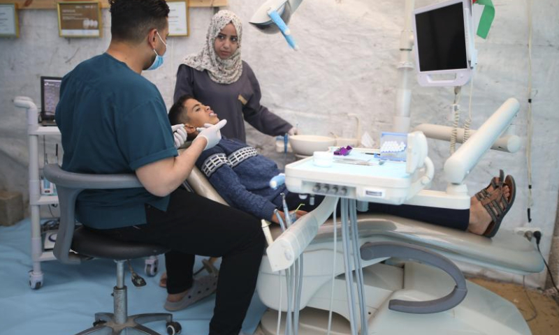 A dentist treats a patient at a temporary clinic in the Nuseirat refugee camp, central Gaza Strip, March 30, 2024. (Xinhua)