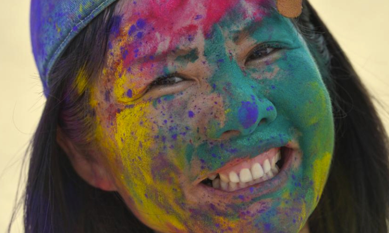 A woman plays with colored powder to celebrate the Holi festival in Pattaya, Thailand, March 23, 2024. (Xinhua/Rachen Sageamsak)