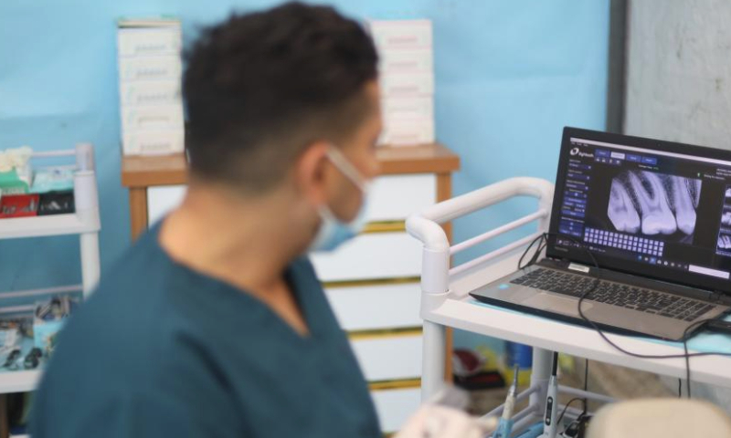 A dentist treats a patient at a temporary clinic in the Nuseirat refugee camp, central Gaza Strip, March 30, 2024. (Xinhua)