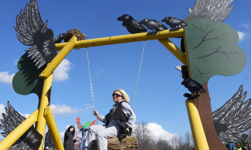 A woman enjoys herself during the swing festival in Sigulda, Latvia, March 30, 2024. (Photo by Edijs Palens/Xinhua)
