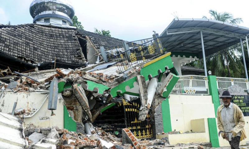 A man walks past a damaged mosque in Tambak village of Bawean Island, East Java, Indonesia, March 24, 2024. An earthquake measuring 6.0 on the Richter scale struck off Indonesia's province of East Java on Friday without triggering a tsunami, the country's meteorology, climatology and geophysics agency said. (Photo by Sahlan Kurniawan/Xinhua)