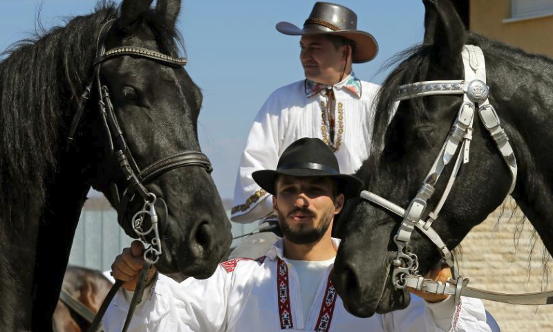A man poses with horses during the celebration of the traditional Tudorita holiday, also known as the Easter of Horses, in Targoviste, 80 km north of Bucharest, Romania, March 23, 2024. Easter of Horses is celebrated by the local Bulgarian community and symbolizes the start of agricultural work in the new year. (Photo by Cristian Cristel/Xinhua)