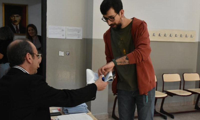 A voter takes ballot papers at a polling station in Istanbul, Türkiye, March 31, 2024. Voters flocked to the polls on Sunday in Istanbul, Türkiye's financial and cultural hub, for the country's local elections. (Photo by Safar Rajabov/Xinhua)