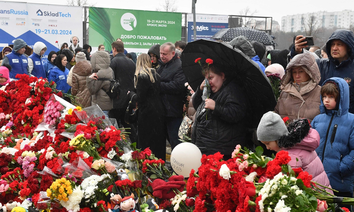 People lay flowers at a makeshift memorial in front of Crocus City Hall in Krasnogorsk on March 24, 2024, as Russia observes a national day of mourning after a massacre that killed at least 137 people. Photo: VCG