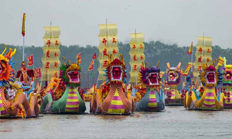People participate in a boat performance during the 2024 Qintong Boat Festival held at Qinhu National Wetland Park in Jiangyan District of Taizhou, east China's Jiangsu Province, April 6, 2024. Hundreds of boats with more than 10,000 boat team members aboard gathered here on Saturday for the Qintong Boat Festival, which has been a centuries-old tradition. (Photo by Tang Dehong/Xinhua)

