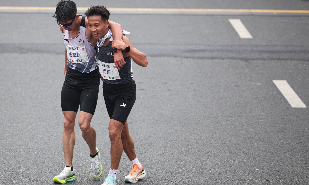 Chinese runners He Jie (right) and Yang Shaohui hug each other after finishing the 2024 Wuxi Marathon on March 24, 2024 in Wuxi, East China's Jiangsu Province. The 25-year-old He clocked two hours, six minutes and 57 seconds, setting China's new national men's marathon record. Yang was the second-best Chinese runner at the event with a time of two hours, seven minutes and 26 seconds. Photo: VCG