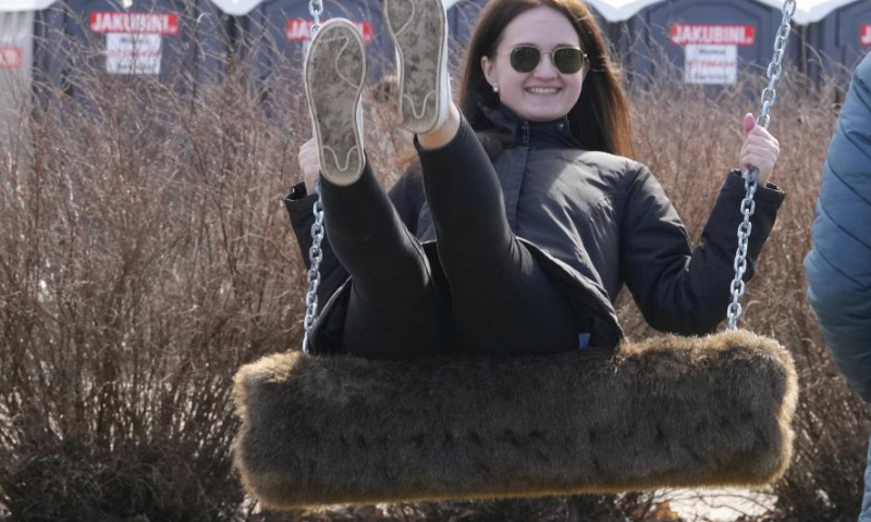 A woman enjoys herself during the swing festival in Sigulda, Latvia, March 30, 2024. (Photo by Edijs Palens/Xinhua)