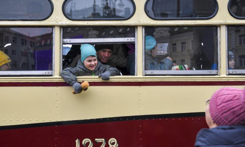 People look out from a window of a tram after a parade of retro tramways in Moscow, Russia, on April 6, 2024. The parade of retro tramways was held on Saturday to mark the 125th anniversary of the opening of the first tram line in Moscow. (Photo by Alexander Zemlianichenko Jr/Xinhua)