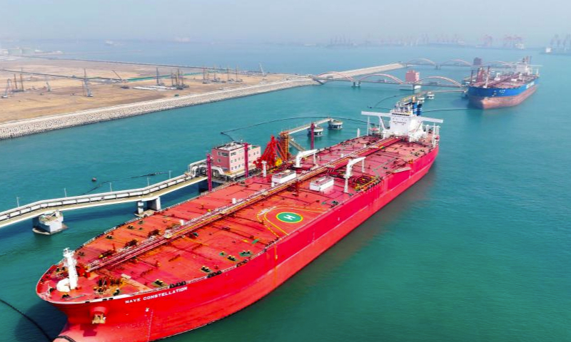 An aerial drone photo taken on March 29, 2024 shows a vessel offloading fuel at an oil terminal of Lanshan Area of Rizhao Port in Rizhao, east China's Shandong Province. The cargo throughput of Rizhao Port saw year-on-year growth of 6.7 percent in the first quarter of this year, among which container throughput hiked by 15.3 percent year-on-year. (Xinhua/Guo Xulei)