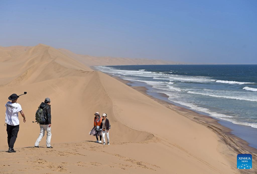 Tourists visit the Sandwich Harbor at Namib-Naukluft National Park in Namibia, on March 24, 2024. In Namibia's Namib-Naukluft National Park, located 400 kilometers from the capital city of Windhoek, there is a scenic spot known as Sandwich Harbor. With its unique half sea and half desert scenery, it attracts tourists from around the world.(Photo: Xinhua)