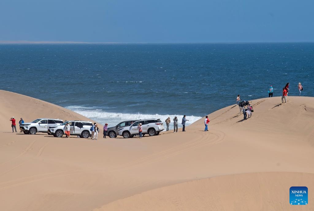 Tourists visit the Sandwich Harbor at Namib-Naukluft National Park in Namibia, on March 24, 2024. In Namibia's Namib-Naukluft National Park, located 400 kilometers from the capital city of Windhoek, there is a scenic spot known as Sandwich Harbor. With its unique half sea and half desert scenery, it attracts tourists from around the world.(Photo: Xinhua)