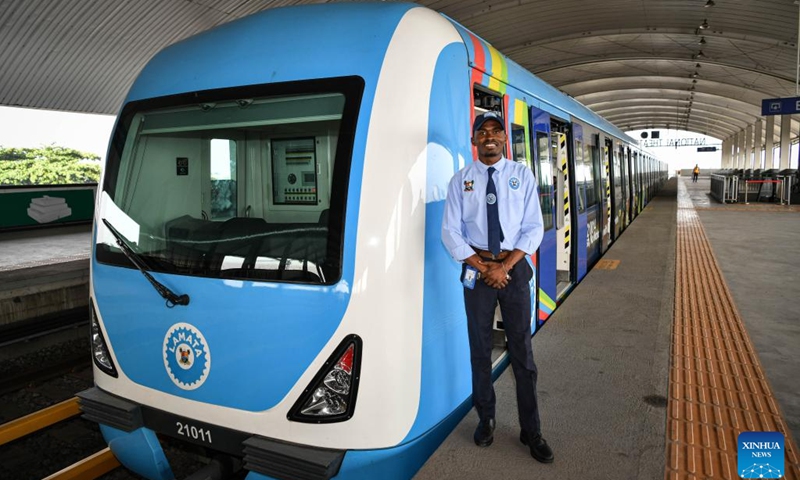 A local driver is pictured beside a train of the Lagos Rail Mass Transit (LRMT) Blue Line in Lagos, Nigeria, March 2, 2024. Undertaken by China Civil Engineering Construction Corporation (CCECC) in July 2010 and completed in Dec. 2022, the first phase of the Lagos Rail Mass Transit (LRMT) Blue Line corridor spans 13 km and covers five stations. It began commercial operation in Sept. of 2023.(Photo: Xinhua)