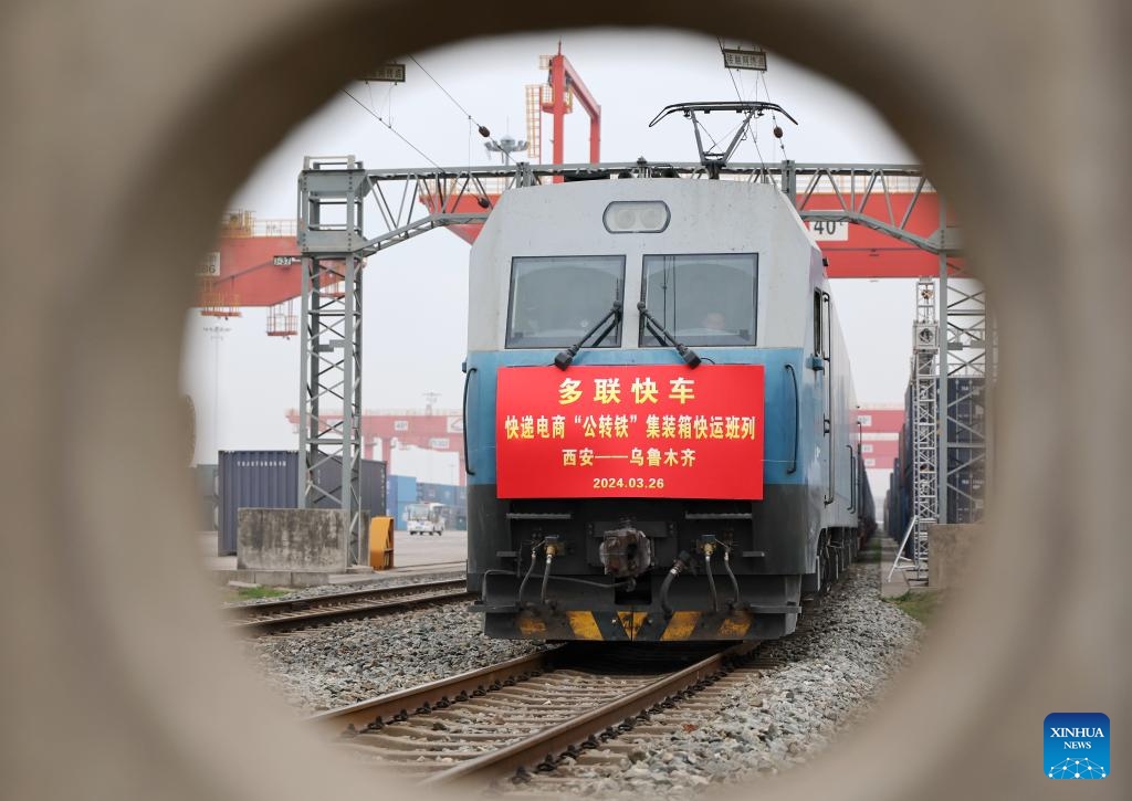 An intermodal express train loaded with containers of e-commerce goods departs from Xi'an international port station in Xi'an, northwest China's Shaanxi Province, March 26, 2024. The intermodal express train X387 bound for Urumqi in northwest China's Xinjiang left Xi'an on Tuesday, marking the official operation of regular freight train service for e-commerce goods between the two cities.(Photo: Xinhua)
