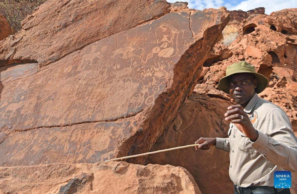 A tourist guide introduces to visitors at the Twyfelfontein rock engraving site in Kunene Region, Namibia, March 26, 2024. Twyfelfontein is one of the largest and most concentrated sites of rock engravings in Africa to date. The site was recognized by UNESCO as Namibia's first World Heritage in 2007.(Photo: Xinhua)
