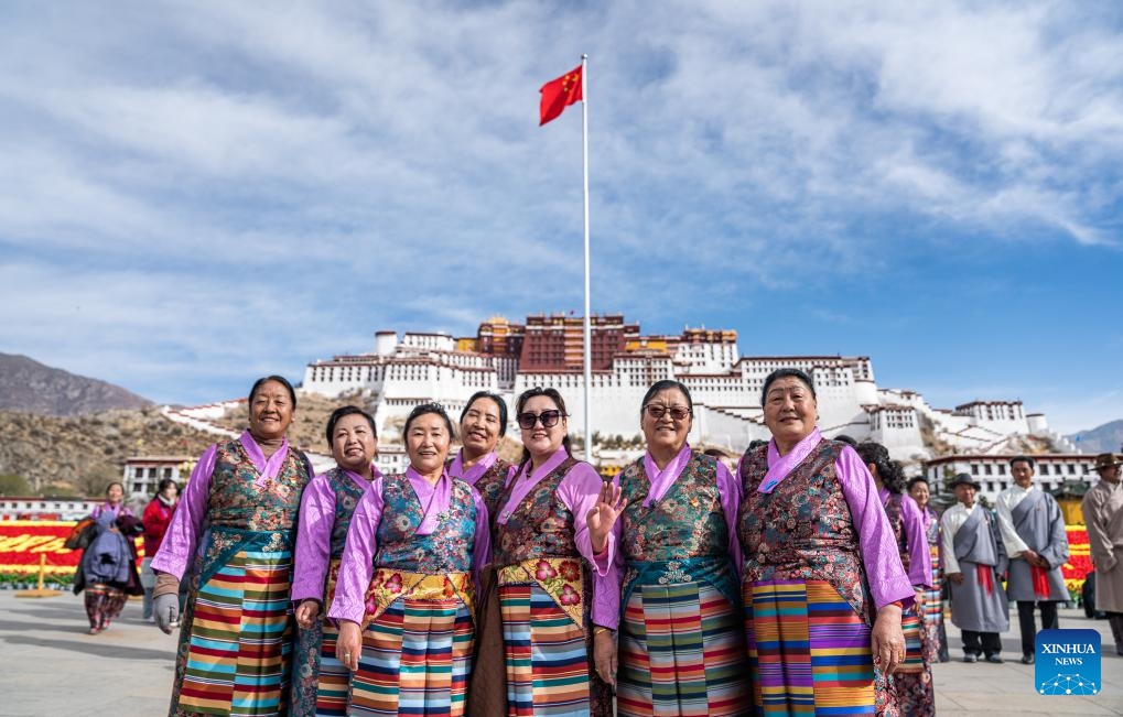People pose for photos after a flag-raising ceremony to celebrate the Serfs' Emancipation Day at the square in front of the Potala Palace in Lhasa, capital of southwest China's Xizang Autonomous Region, March 28, 2024. On March 28, 1959, people in Xizang launched the democratic reform, freeing a million serfs. In 2009, the regional legislature announced March 28 as the day to commemorate the emancipation of the one million serfs.(Photo: Xinhua)