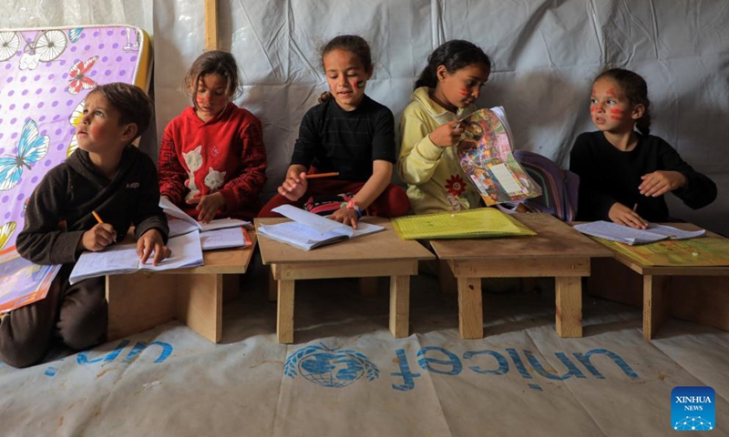 Palestinian children study at a temporary classroom in the southern Gaza Strip city of Rafah, March 27, 2024. The heavy bombardment against Gaza by Israel has resulted in direct hits on 212 schools within the enclave, according to analysis partnered with the United Nations released on Wednesday. Satellite images have shown that at least 53 schools have been completely destroyed since the conflict began on Oct. 7, 2023.(Photo: Xinhua)