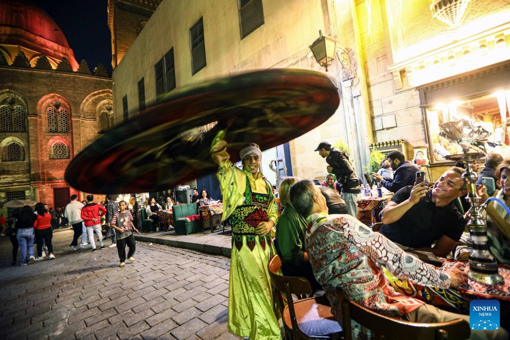 A Tanoura dancer performs outside a coffee shop on Muizz Street during Ramadan in Cairo, Egypt, on April 1, 2024.(Photo: Xinhua)