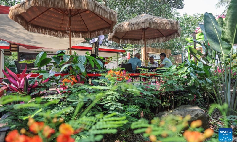 Tourists rest at a water tower coffee house in Dashan Village of Longmen Township, Ding'an County, south China's Hainan Province, April 4, 2024. In recent years, Longmen Township in Ding'an County of Hainan has been developing its coffee tourism industry to attract tourists and promote its development. (Xinhua/Zhang Liyun)